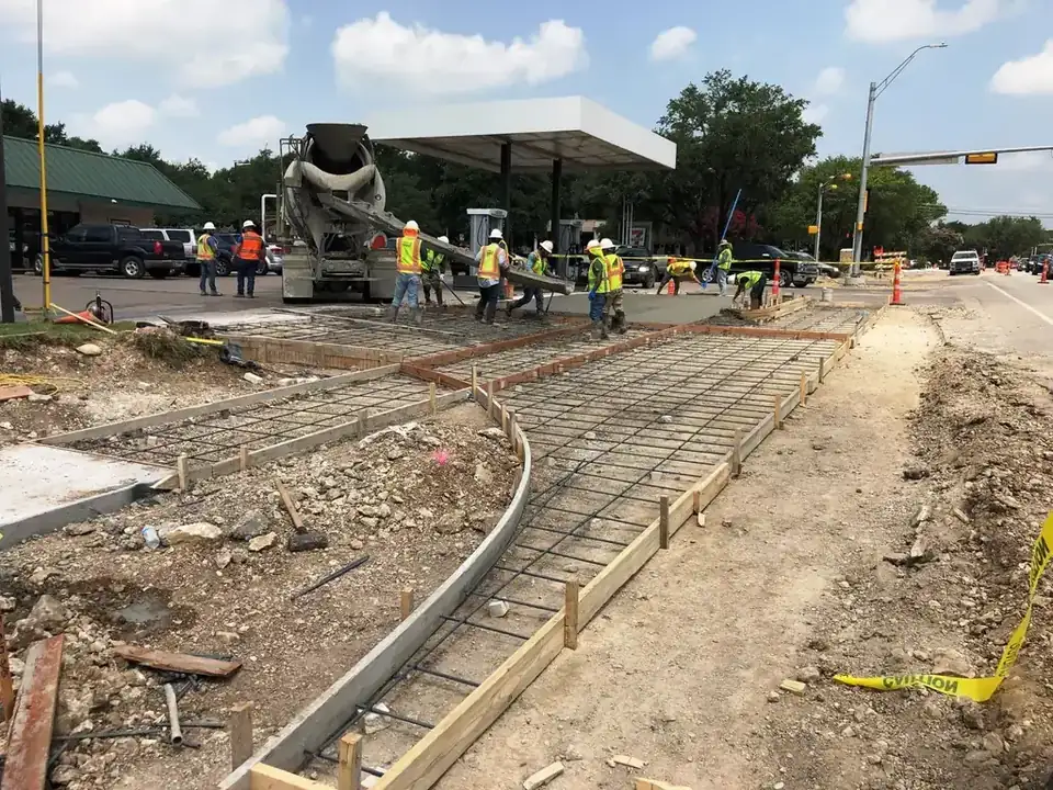 An Aaron Concrete crew placing concrete off a mixer chute at a live Austin intersection