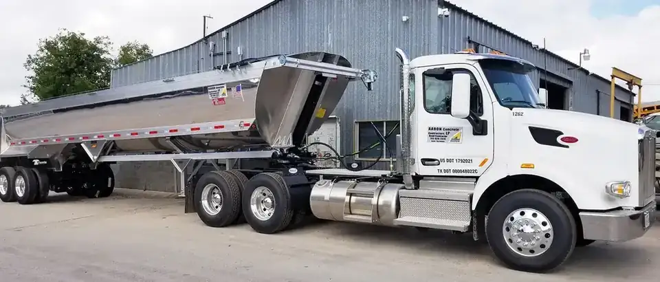 An Aaron Concrete Peterbilt tractor and polished aluminium belly-dump trailer, the door lettered Aaron Concrete Contractors, Road Contractor, Austin and San Antonio
